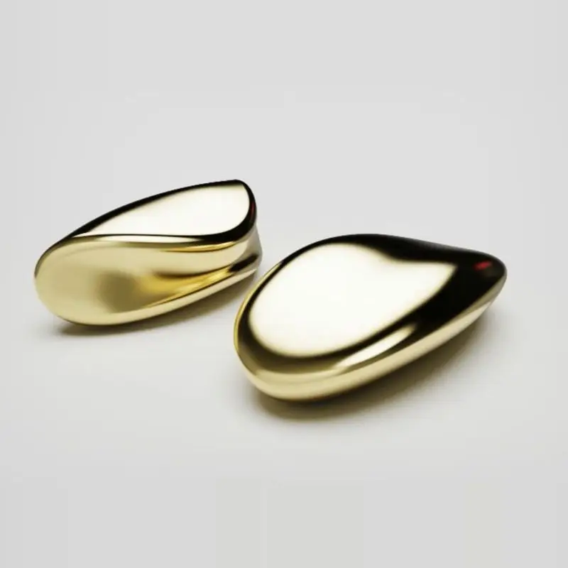 Two polished gold pebble shapes, studio rendered on a pale grey ground.
