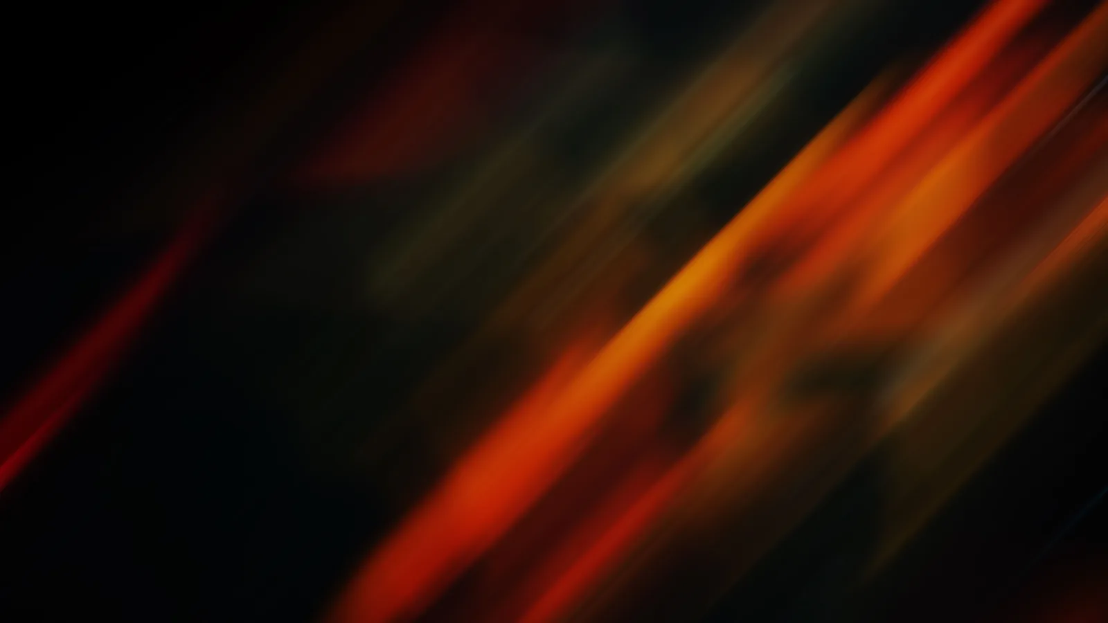 Warm orange and red streaks of light blurred diagonally across a near-black background, a long exposure.
