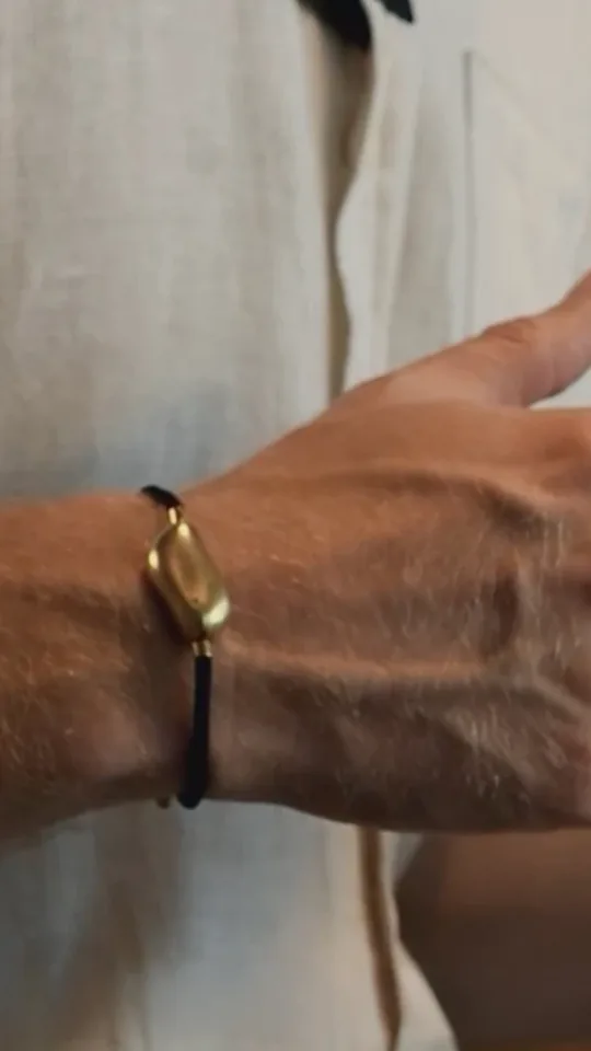 A hand at rest wearing the Sou band on a fine cord